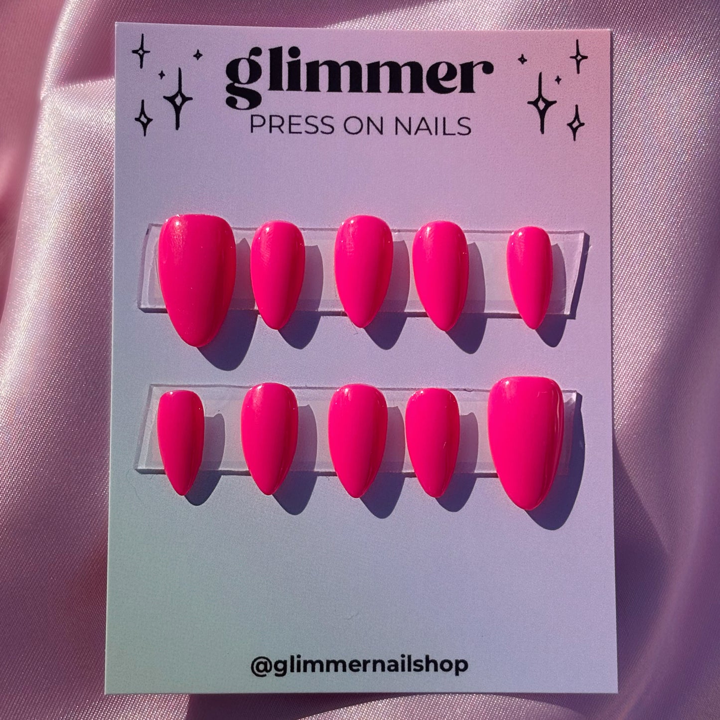 Glimmer press-on nails packaging with pink nails on a pink background
