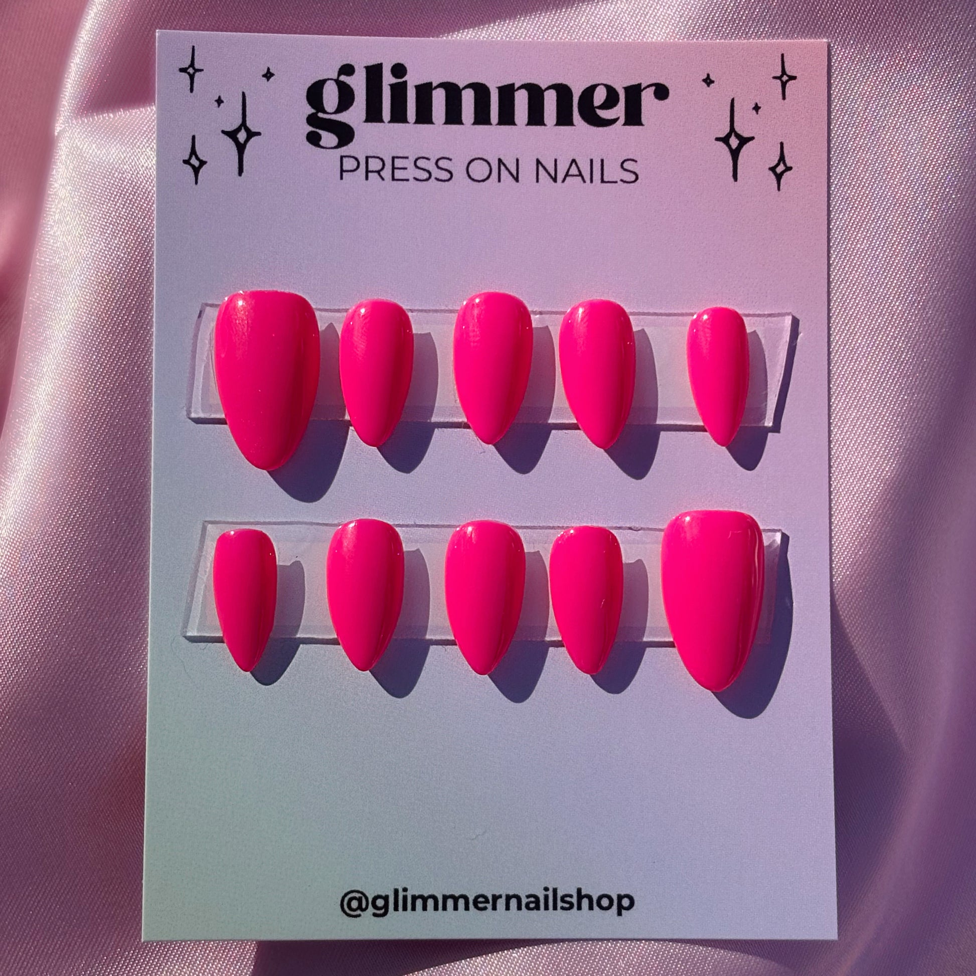 Glimmer press-on nails packaging with pink nails on a pink background
