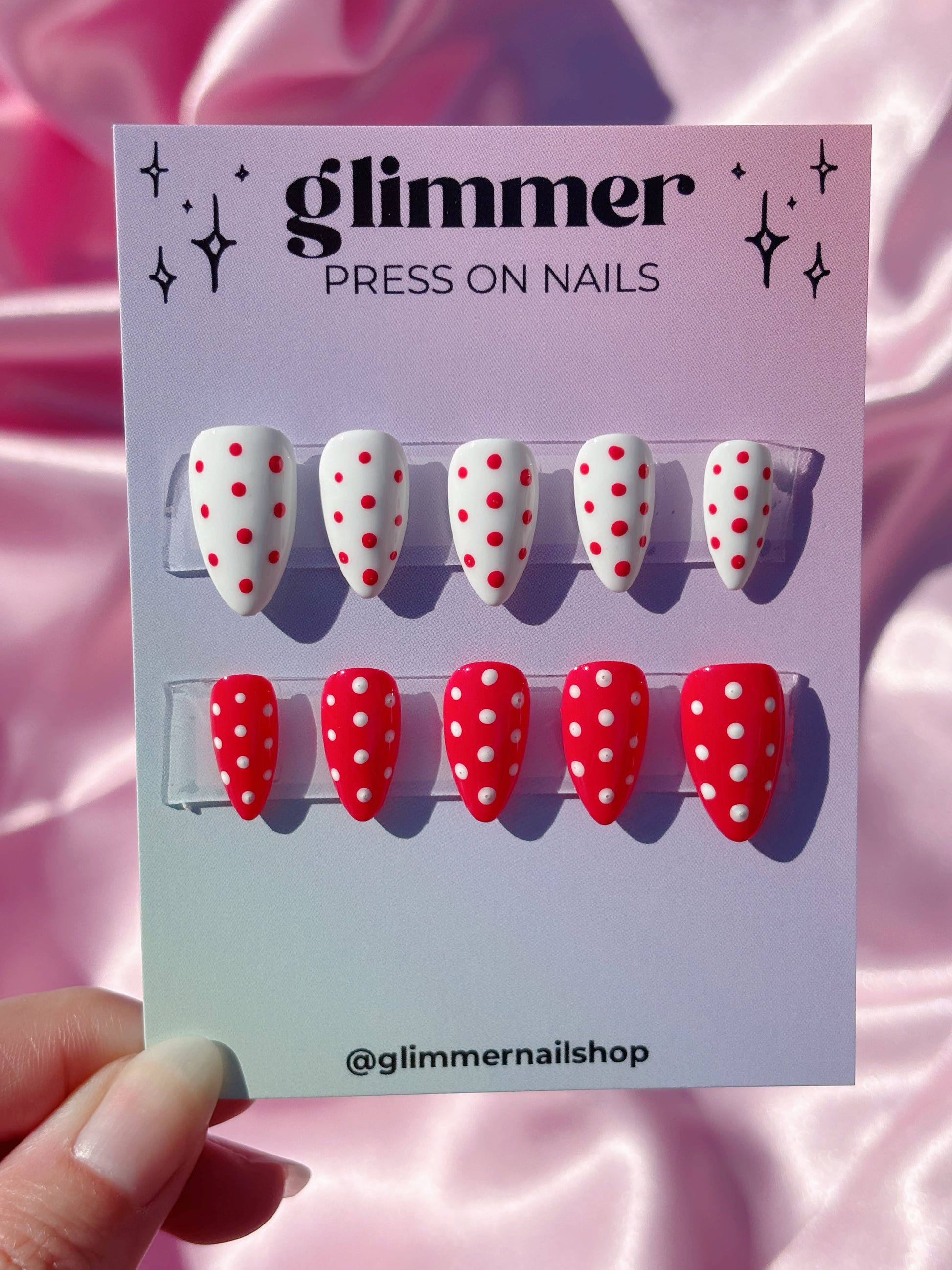 Glimmer press on nails with red and white polka dot design on a pink background